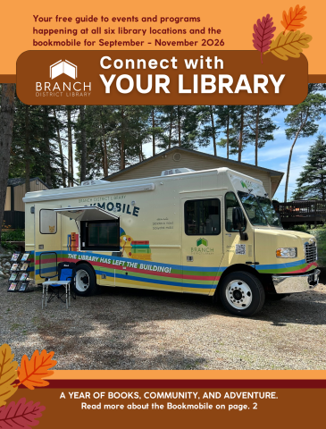 library bookmobile set up outside with trees and blue sky in the background
