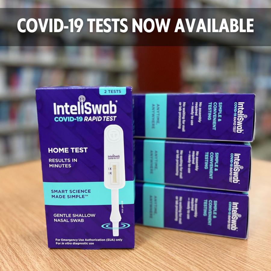 pictures of covid-19 tests on a table with book shelves in the background. 